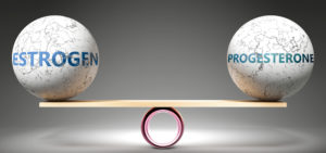 Estrogen ball and progesterone ball balancing on wood