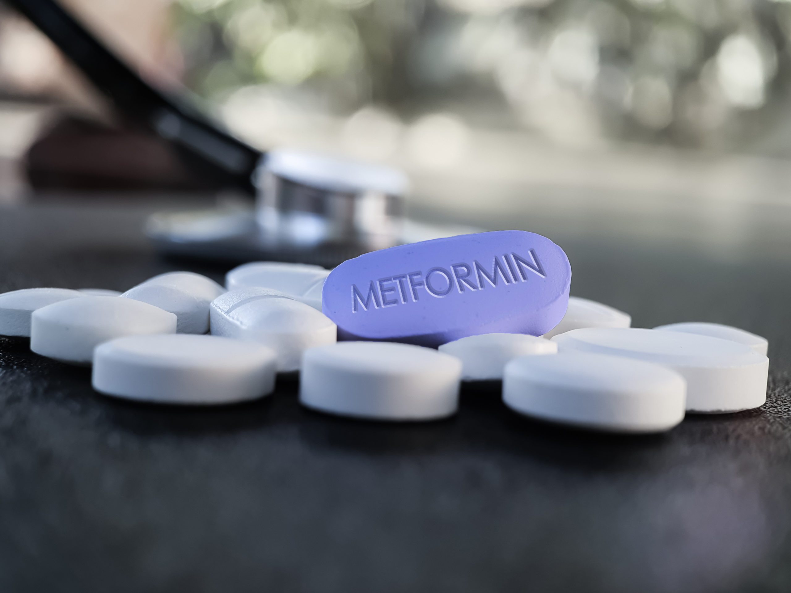 A blue Metformin pill surrounded by white pills