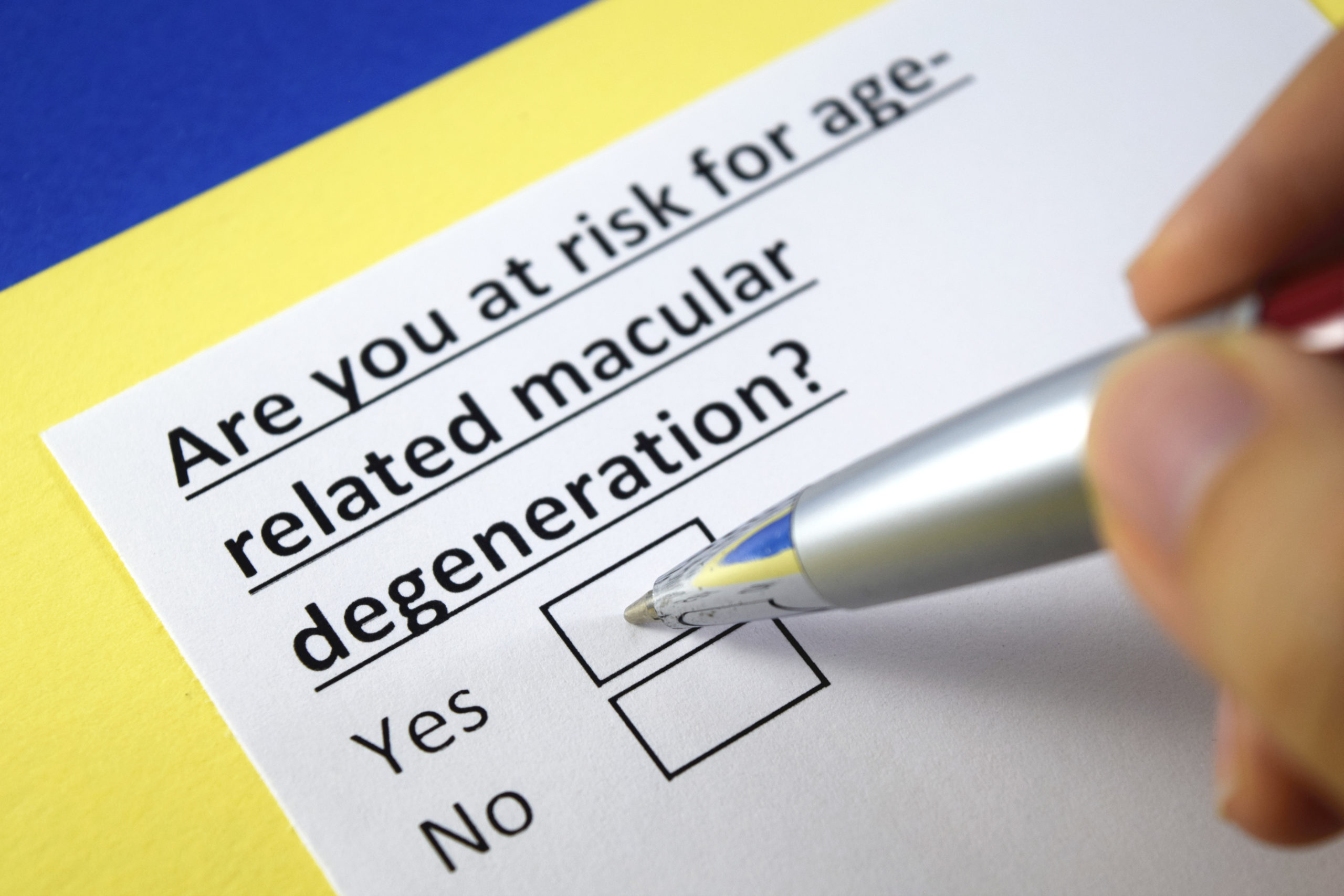 A pen on a box ticking yes to the question 'Are you at risk for age-related macular degeneration?'