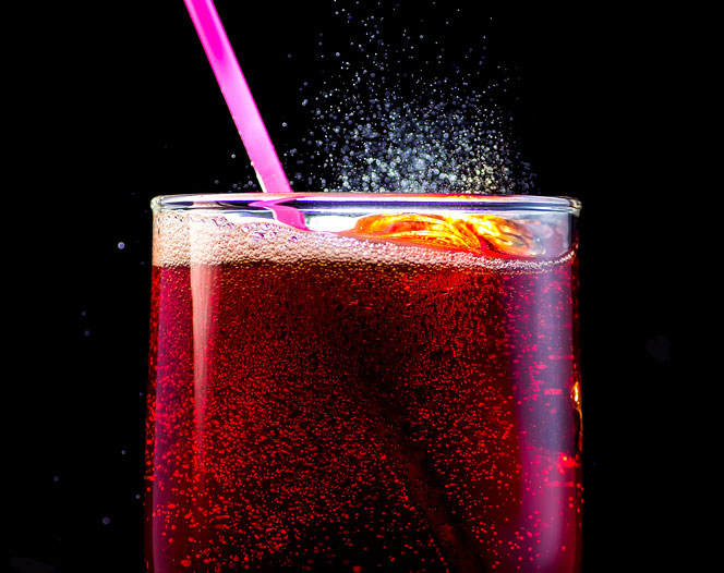 Close up of fizzy soda with a pink straw