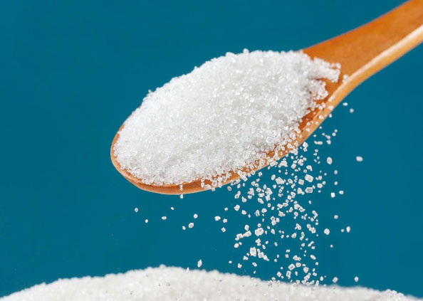 Close up of sugar on a small wooden spoon