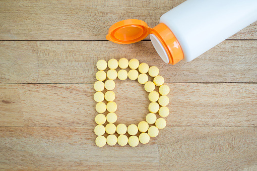 Pills spilled out of the bottle to form the letter D